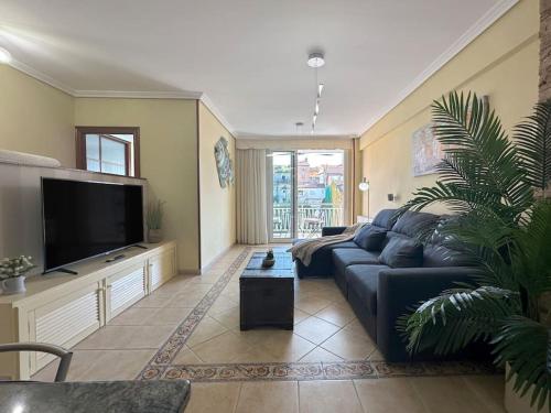 a living room with a blue couch and a tv at Apartamento en centro de Laredo in Laredo