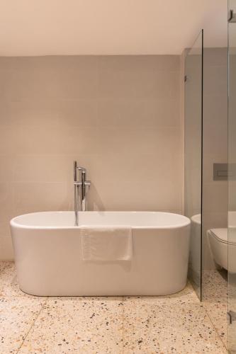 a white bath tub in a bathroom with a toilet at Gordonia Ma'ale Hahamisha in Maale Hachamisha