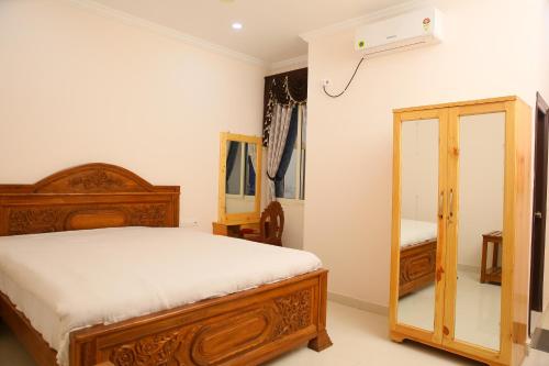 a bedroom with a wooden bed and a mirror at Saba executive rooms and apartments in Hyderabad