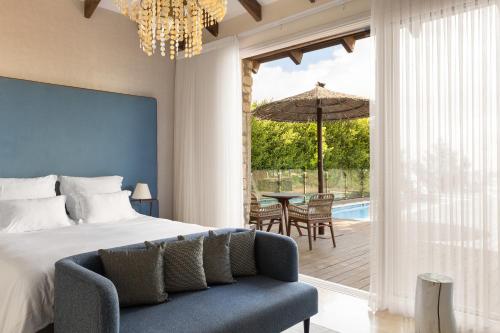 a bedroom with a bed and a chair and a patio at Gordonia Ma'ale Hahamisha in Maale Hachamisha