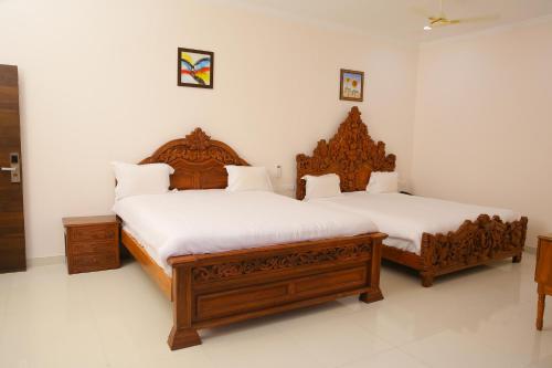 two beds in a room with white walls at Saba executive rooms and apartments in Hyderabad