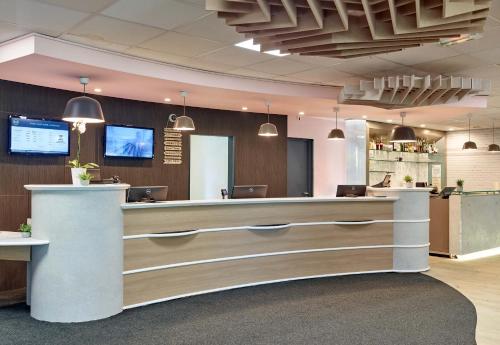 a lobby of a restaurant with a reception counter at B&B HOTEL Paris Nord 2 CDG Aéroport in Roissy-en-France
