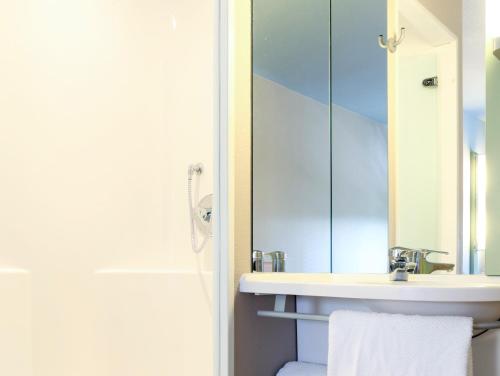 a bathroom with a sink and a mirror at Ibis budget Hamburg City Ost in Hamburg