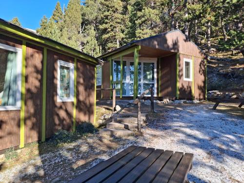 a building with a porch next to a house at Bungalow en parc natural del Ter 2000 metres in Setcases