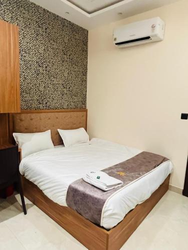 a bedroom with a bed with a fan on the wall at Goel Villa and Hotel in Allāhābād Junction