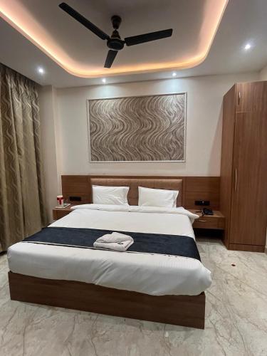 a bedroom with a large bed with a ceiling fan at Goel Villa and Hotel in Allāhābād Junction