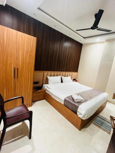 a bedroom with a bed and a chair at Goel Villa and Hotel in Allāhābād Junction