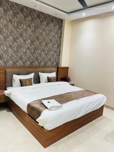 a bedroom with a large bed with white sheets at Goel Villa and Hotel in Allāhābād Junction