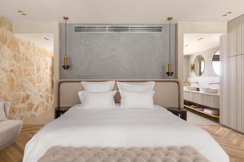 a bedroom with a large white bed with two pillows at Gordonia Ma'ale Hahamisha in Maale Hachamisha