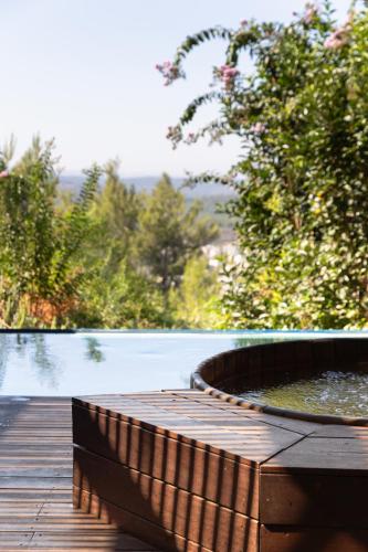 a wooden deck with a pond on the side of a pool at Gordonia Ma'ale Hahamisha in Maale Hachamisha
