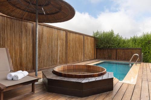 a hot tub sitting on a deck next to a swimming pool at Gordonia Ma'ale Hahamisha in Maale Hachamisha