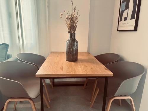 a table with a vase with flowers on it at Tzane Luxury Suites - Luxury Suites in the City Center for Comfort & Privacy By Villa Mana Gers in Zakynthos Town