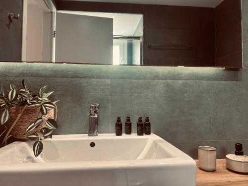 a white sink in a bathroom with a mirror at Tzane Luxury Suites - Luxury Suites in the City Center for Comfort & Privacy By Villa Mana Gers in Zakynthos Town