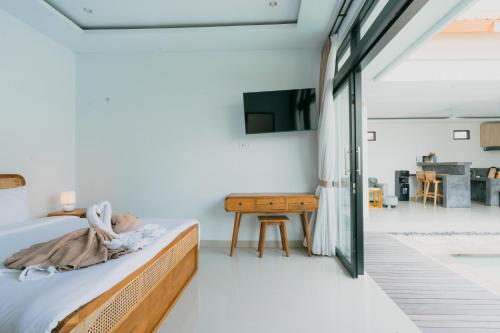 a bedroom with a bed and a table at The Lavana Bliss Two Villa Nyanyi Beach in Canggu