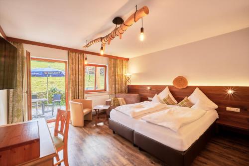 a hotel room with a bed and a table and chairs at Landhotel Sportalm in Philippsreut