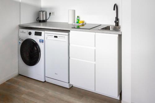 a white kitchen with a washing machine and a sink at Kleines zentrales Apartment in Goch - Netflix in Goch
