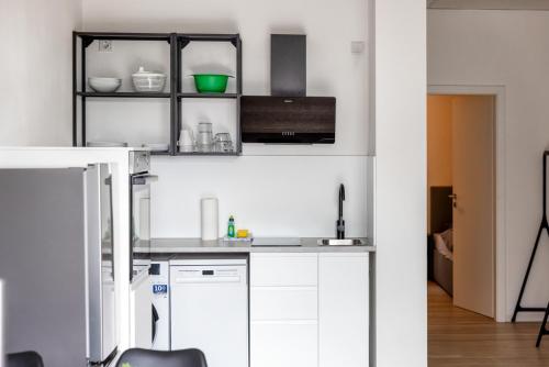 a kitchen with white cabinets and a black shelf at Kleines zentrales Apartment in Goch - Netflix in Goch