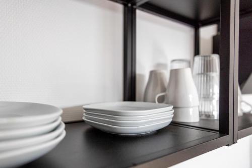 a shelf with plates and other dishes on it at Kleines zentrales Apartment in Goch - Netflix in Goch