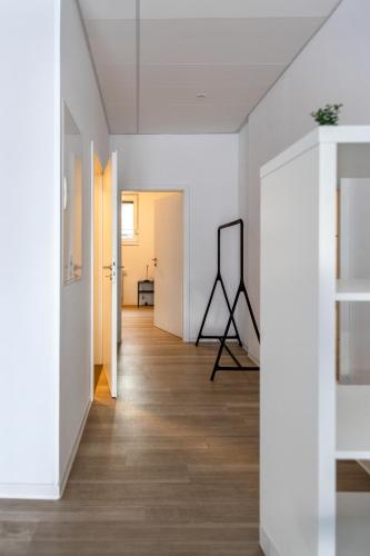 a hallway with white walls and wood floors and a mirror at Kleines zentrales Apartment in Goch - Netflix in Goch