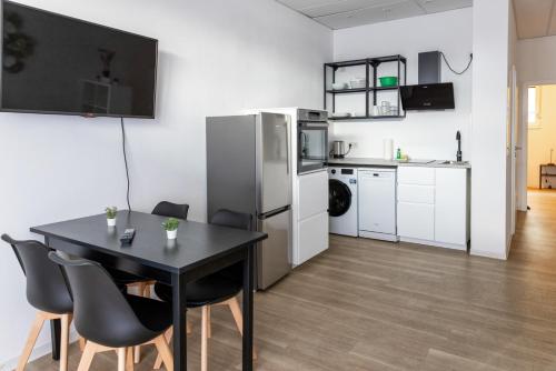 a kitchen and dining room with a table and refrigerator at Kleines zentrales Apartment in Goch - Netflix in Goch
