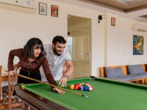 a man and woman playing pool on a pool table at Moustache Rishikesh Luxuria in Rishīkesh