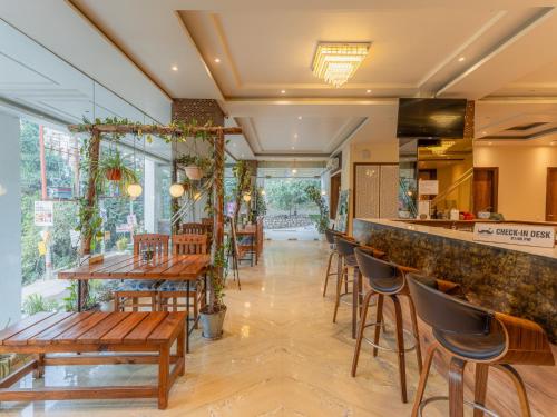a restaurant with a bar with wooden tables and chairs at Moustache Rishikesh Luxuria in Rishīkesh