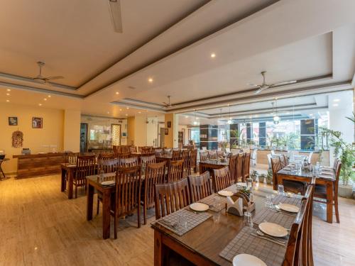 a dining room with wooden tables and chairs at Moustache Rishikesh Luxuria in Rishīkesh