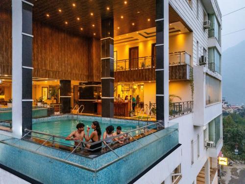 a group of people sitting in the pool of a hotel at Moustache Rishikesh Luxuria in Rishīkesh