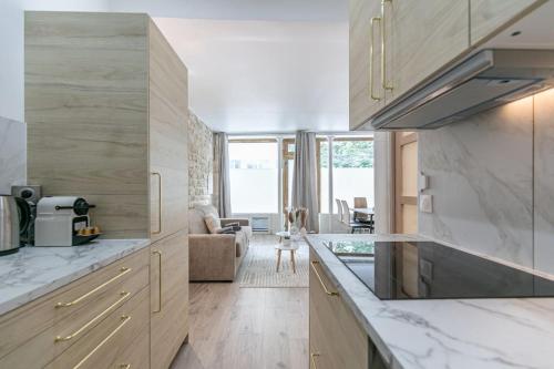 une cuisine avec des comptoirs en marbre et un salon dans l'établissement Cosy appartement Paris 20e, à Paris