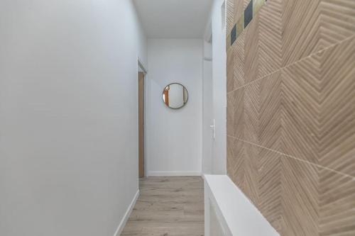 un couloir avec une porte blanche et un miroir dans l'établissement Cosy appartement Paris 20e, à Paris