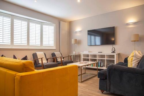 a living room with couches and a tv on the wall at Stunning Rare Soho Gem in London