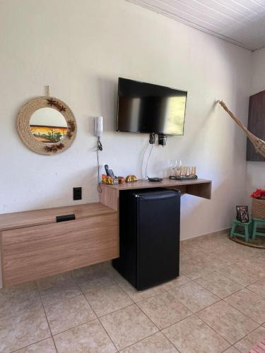 a room with a tv on a wall with a table at Apt Flat 225 Condomínio Pedra do Rodeadouro in Bonito
