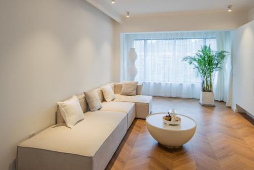 a living room with a white couch and a table at Tonight Homestay South Shanxi Road Shanghai in Shanghai