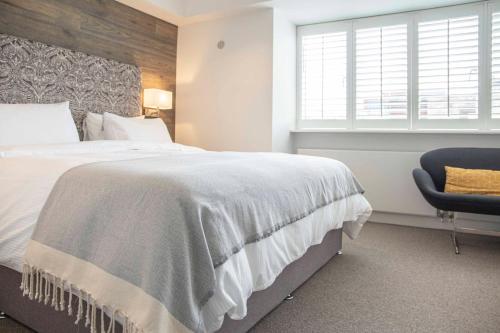 a bedroom with a large bed and a chair at Stunning Rare Soho Gem in London