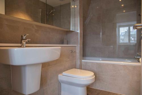 a bathroom with a sink and a toilet and a tub at Stunning Rare Soho Gem in London