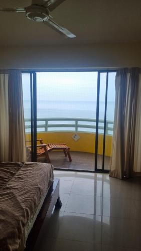 a bedroom with a large window with a view of the ocean at Apartment with wonderful view, Mae Ramphueng Beach, Rayong in Rayong