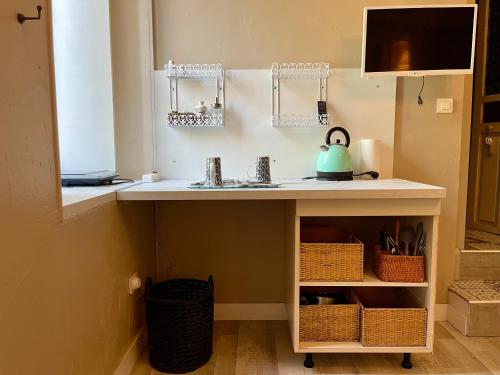 a kitchen counter with a sink and a kettle on it at Côté Cité appartements - Parking privé - 100m Cité médiévale in Carcassonne