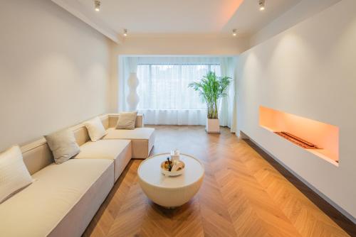 a living room with a white couch and a table at Tonight Homestay South Shanxi Road Shanghai in Shanghai