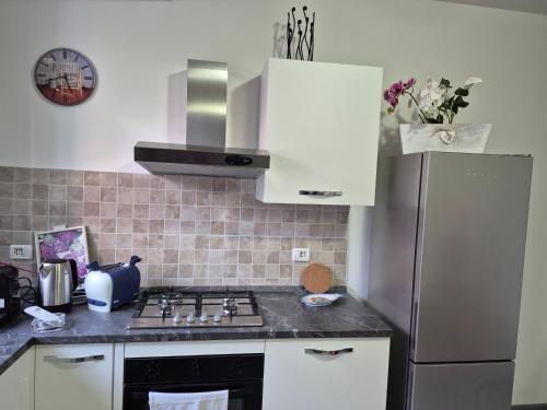 a kitchen with a stove and a refrigerator at Le Mimose Holiday House di Como - Grandate in Grandate