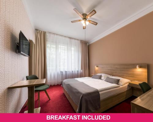 a hotel room with a bed and a ceiling fan at Hotel Meda of Museum Kampa in Prague