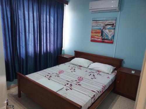 a small bedroom with a bed with red writing on it at Magic Sea Apartments in Larnaka