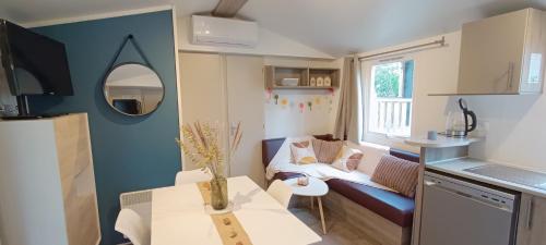 a small living room with a couch and a table at Cozy-House tout confort camping 4 étoiles in Lège-Cap-Ferret