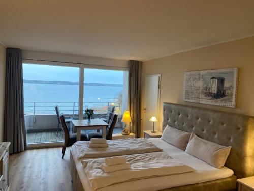 a bedroom with a bed and a view of the ocean at Fördeblick Anna in Glücksburg