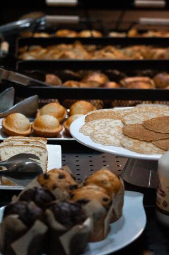 a table topped with plates of pastries and pies at Campanile Villeneuve-Sur-Lot in Pujols Lot et Garonne
