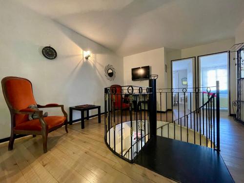a living room with a chair and a table at Côté Cité appartements - Parking privé - 100m Cité médiévale in Carcassonne