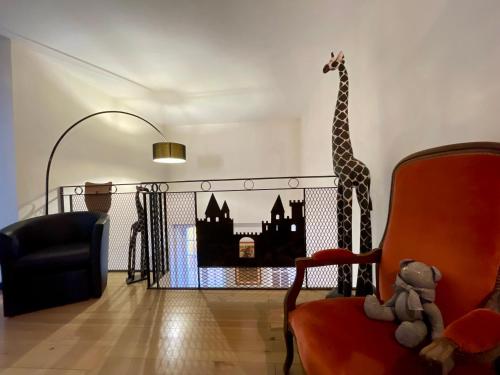 a living room with a giraffe and a chair at Côté Cité appartements - Parking privé - 100m Cité médiévale in Carcassonne