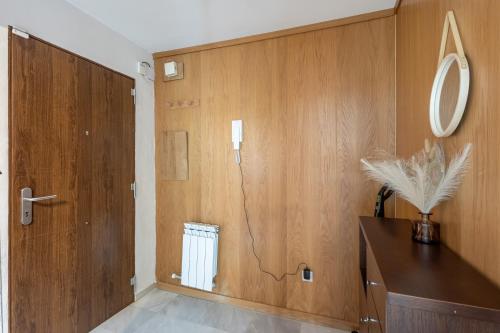 a bathroom with wooden walls and a door with a mirror at Chalet con piscina a 10 minutos de Granada in Ogíjares