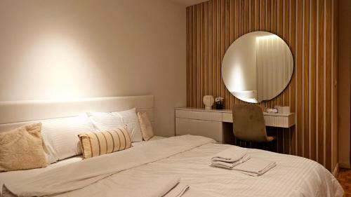 a bedroom with a large white bed with a mirror at Aparte - Standard in Pristina