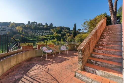 two chairs sitting on a brick patio with stairs at Private Jacuzzi - Villa Bellosguardo in Florence Historic Center in Florence
