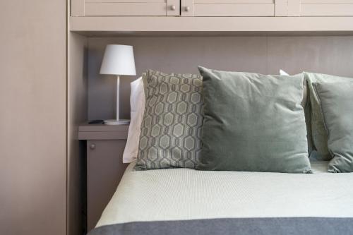 a bedroom with a bed with green pillows and a lamp at Private Jacuzzi - Villa Bellosguardo in Florence Historic Center in Florence